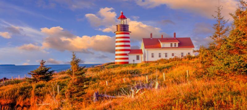 The West Quoddy Head Lighthouse surrounded by brilliantly colored fall foliage