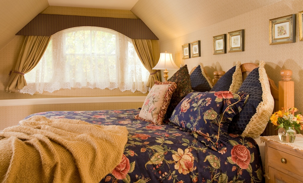 Stay at one of the best Rockland, Maine hotels during any season and enjoy the best hospitality. This guest suite features a king sized bed with unique decor.