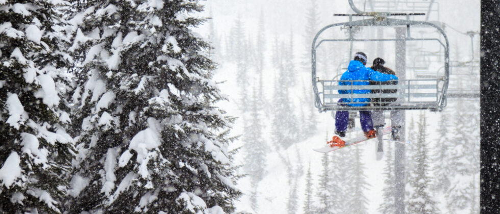 There are so many things to do in Maine in winter, and hopping on the slopes is just one of them. A couple enjoys a chairlift to the top of the slope.