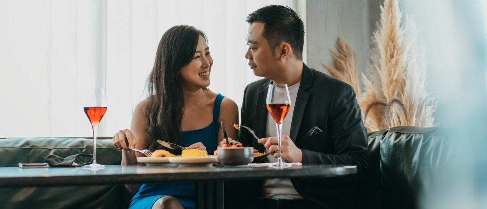 a couple is dining out with glasses of wine on the table