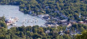 View from Mt. Battie looking down at Camden Harbor. Sailboats are in the marina and houses line the coast.