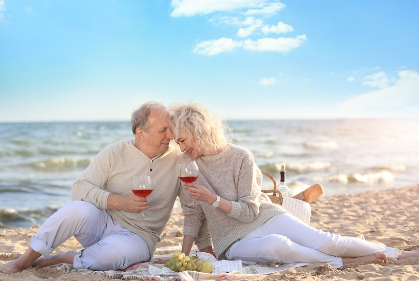 An older couple celebrating their anniversary with a picnic on the beach
