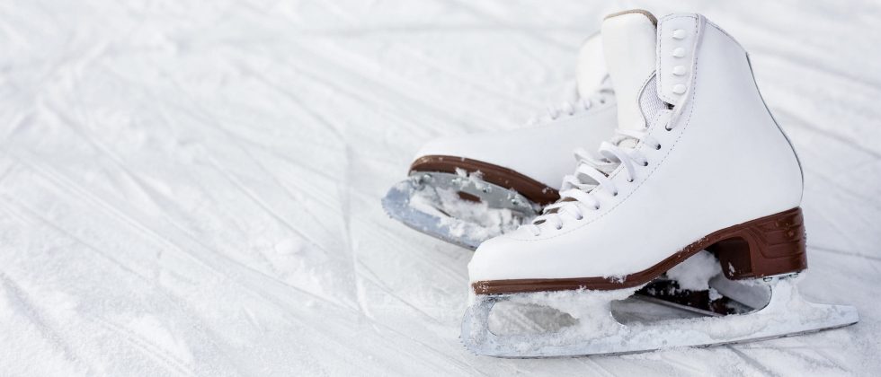 Pair of white ice skates lying in the snow