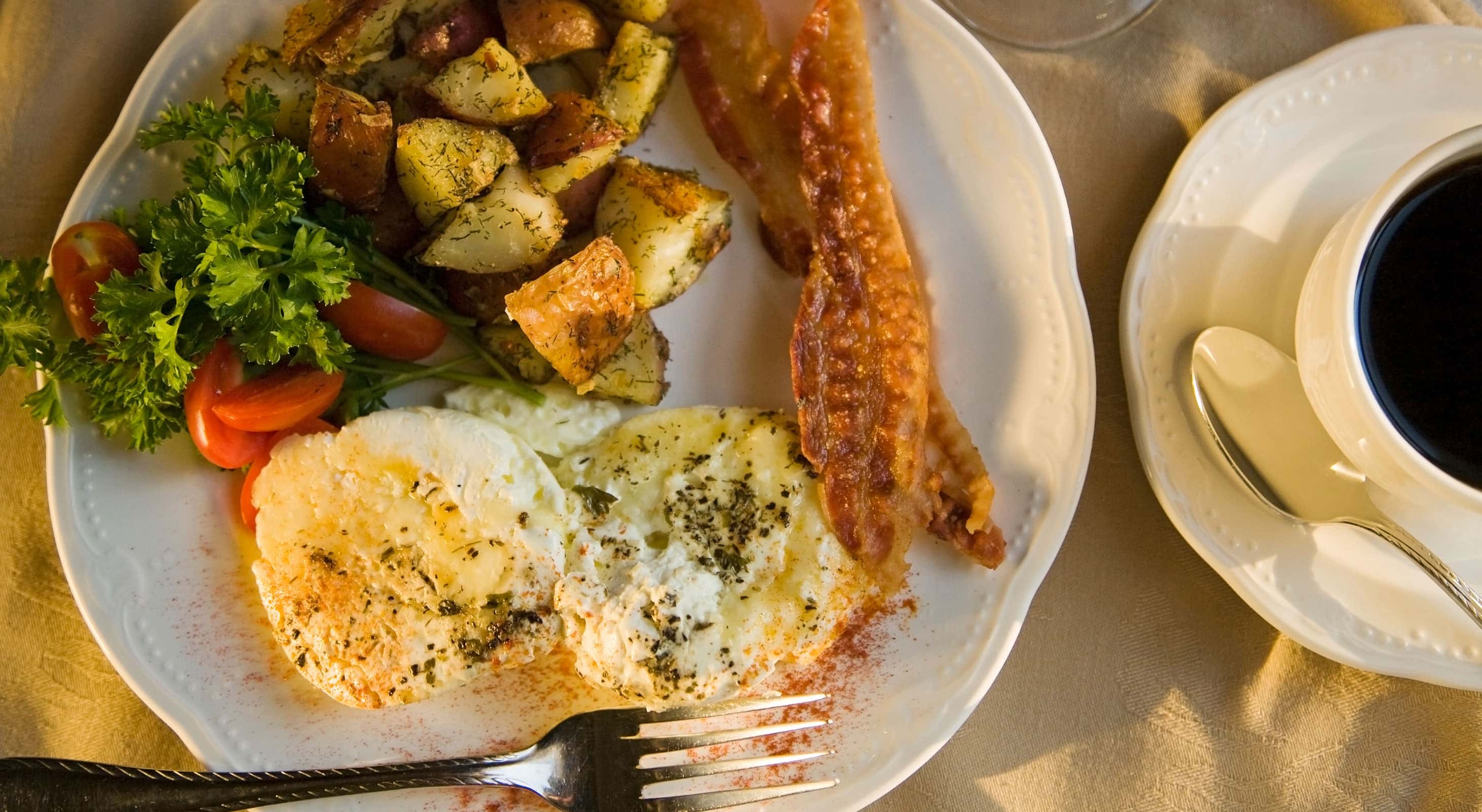 Top-down shot of breakfast egg dish with potatoes and coffee