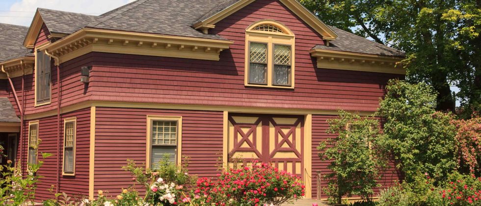 Exterior of the Berry Manor Inn with lush flowery gardens