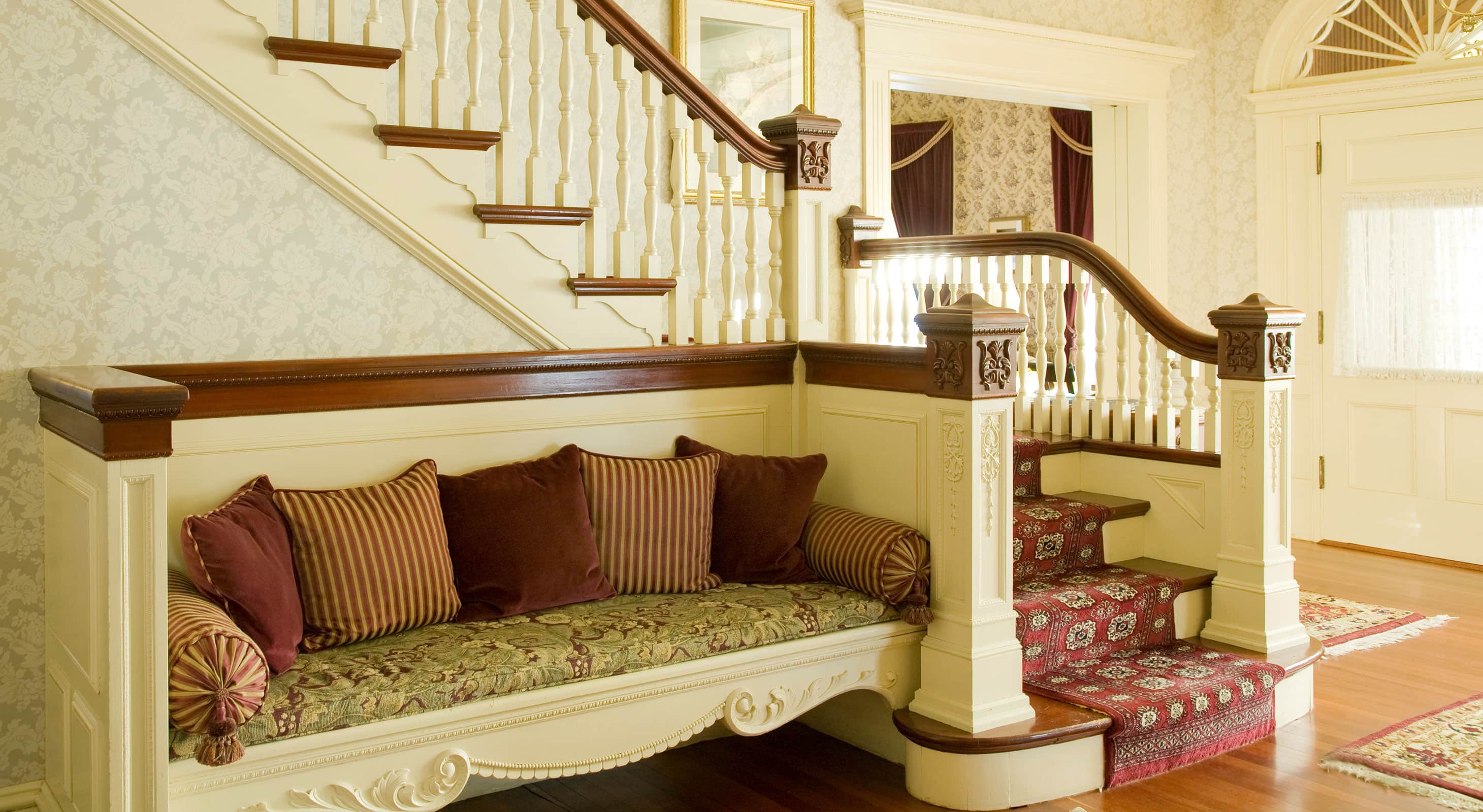 Sitting area next to ornate staircase in the Berry Manor Inn