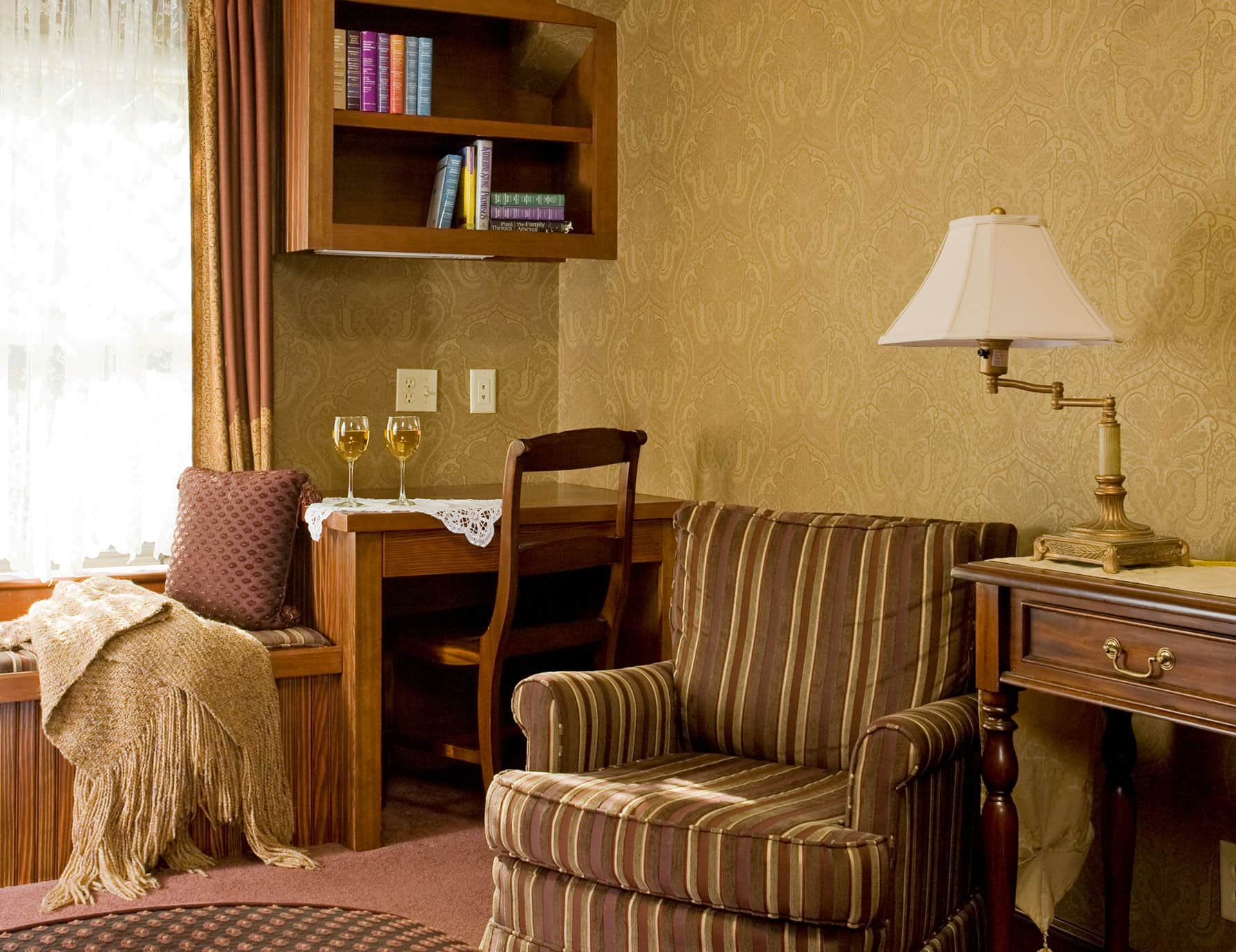 Sitting area with bench, soft chair and champagne glasses in Room 10