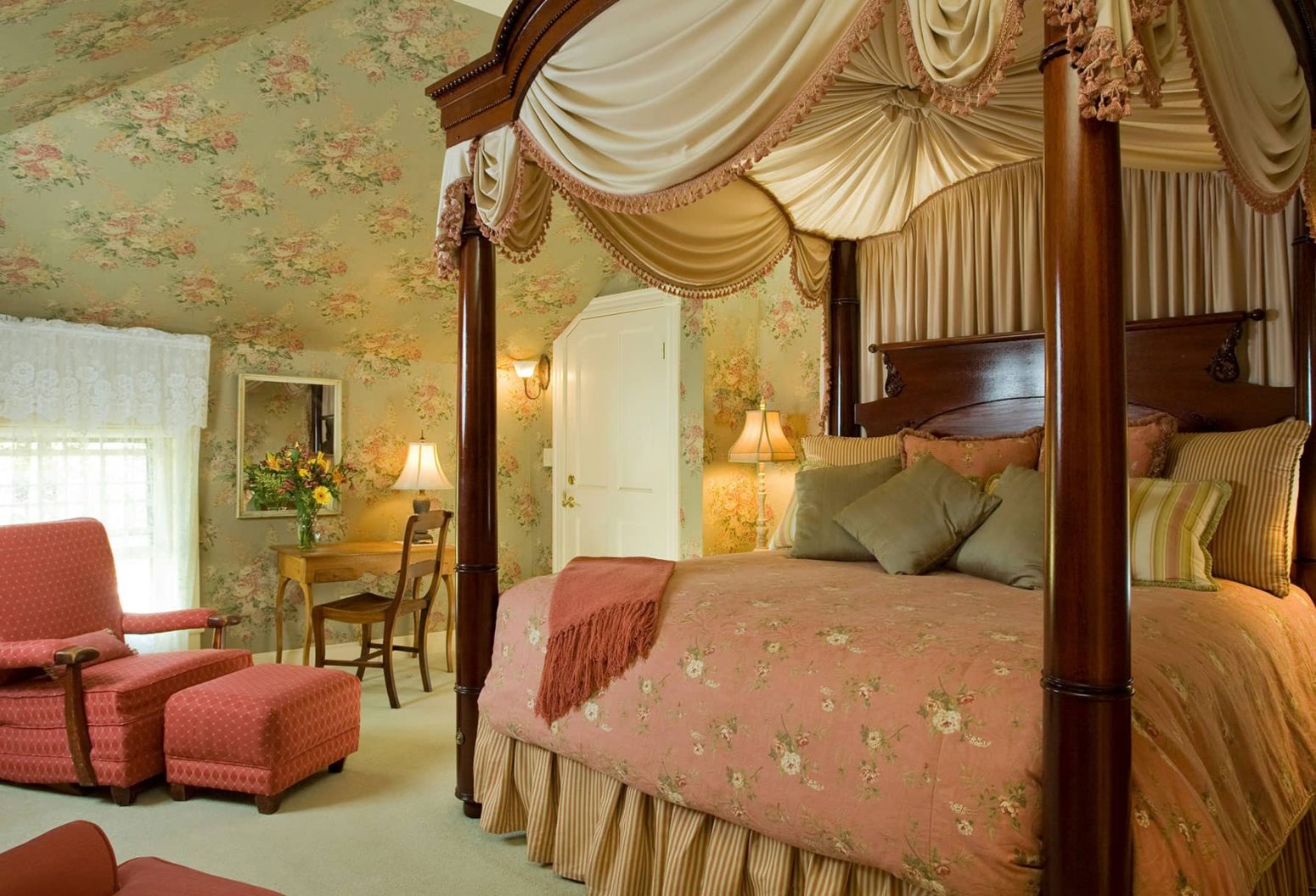 Tall, luxurious Four-poster bed by comfortable sitting area in Room 12