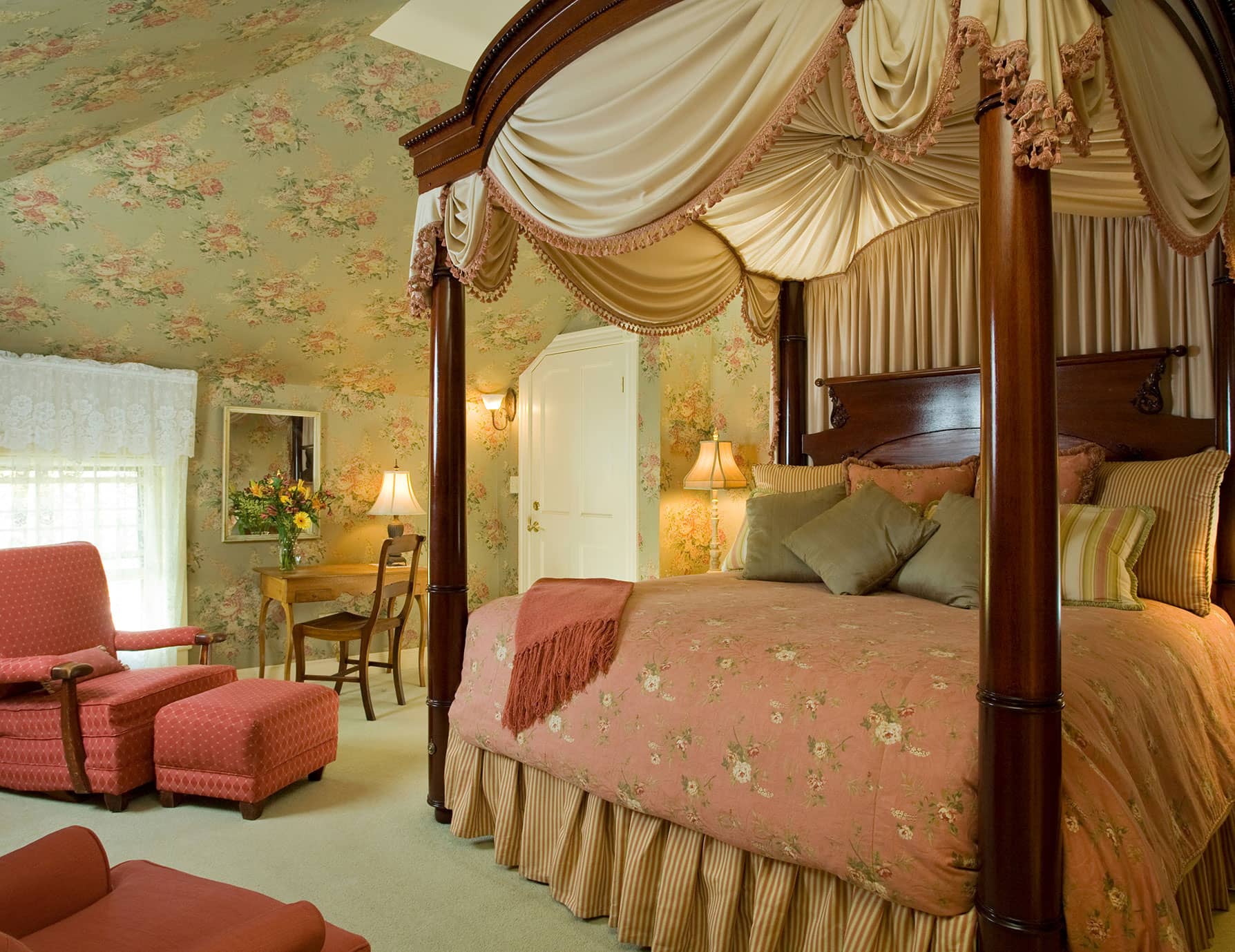 Tall, luxurious Four-poster bed by comfortable sitting area in Room 12