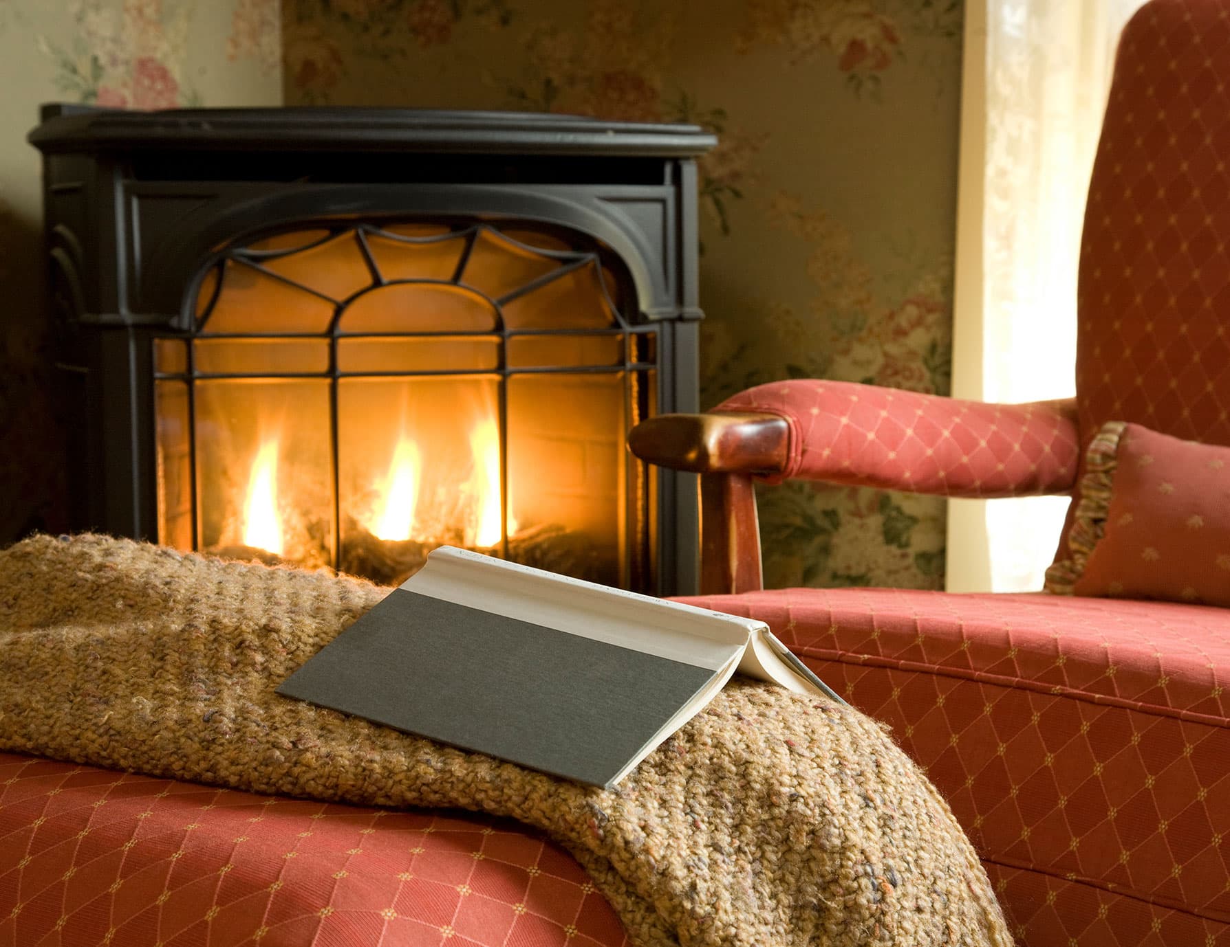 Book on ottoman by warm gas fireplace