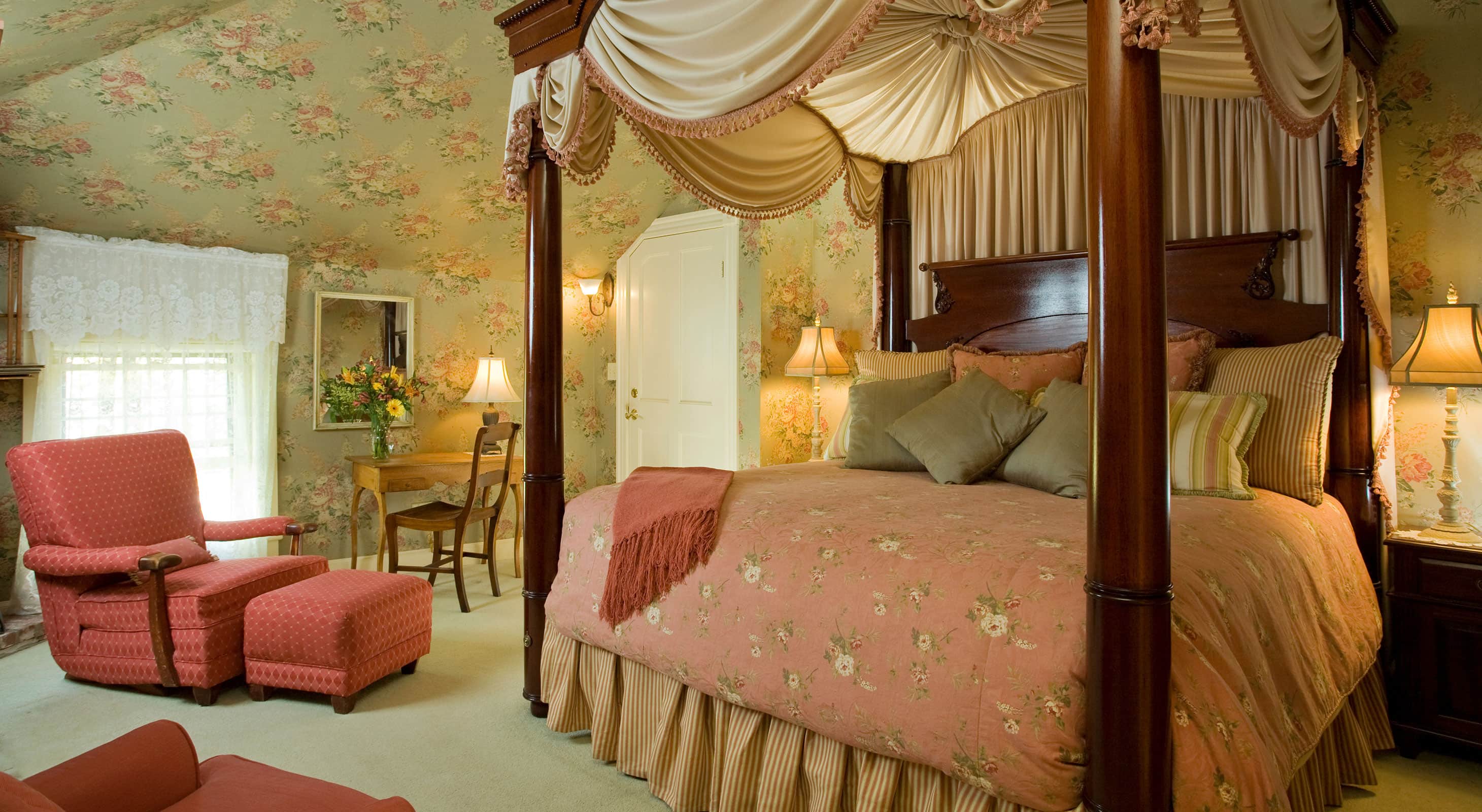 Tall, luxurious four-poster bed by comfortable sitting area in Room 12 - one of the most romantic rooms at our Rockland, Maine Hotel