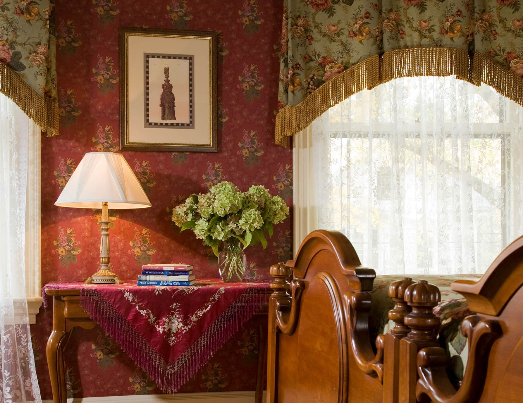 End table by large window at the foot of large bed