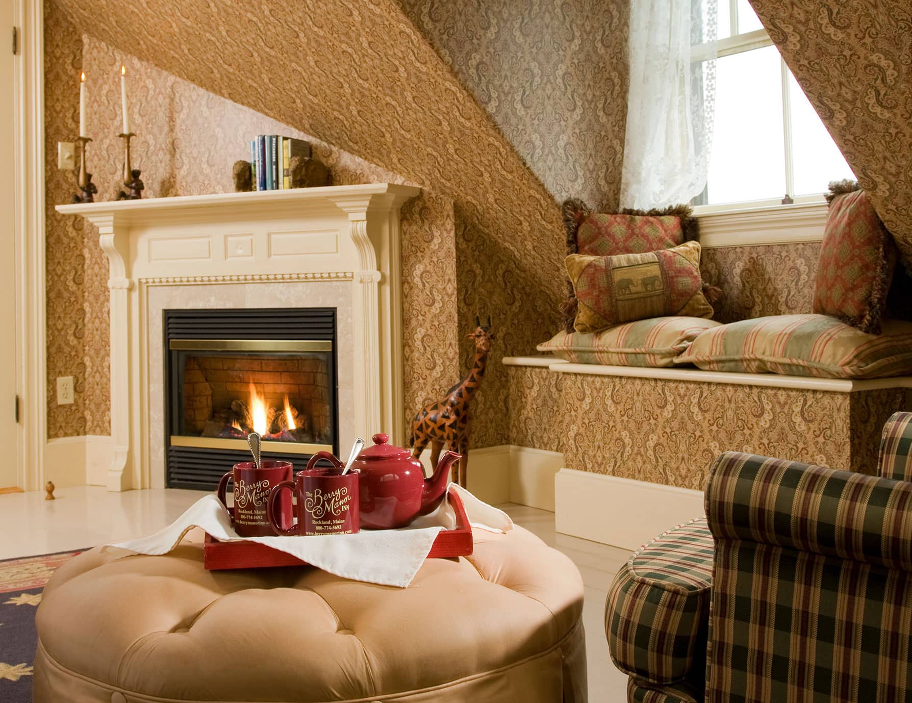 Window sitting area with tea and mugs by fireplace