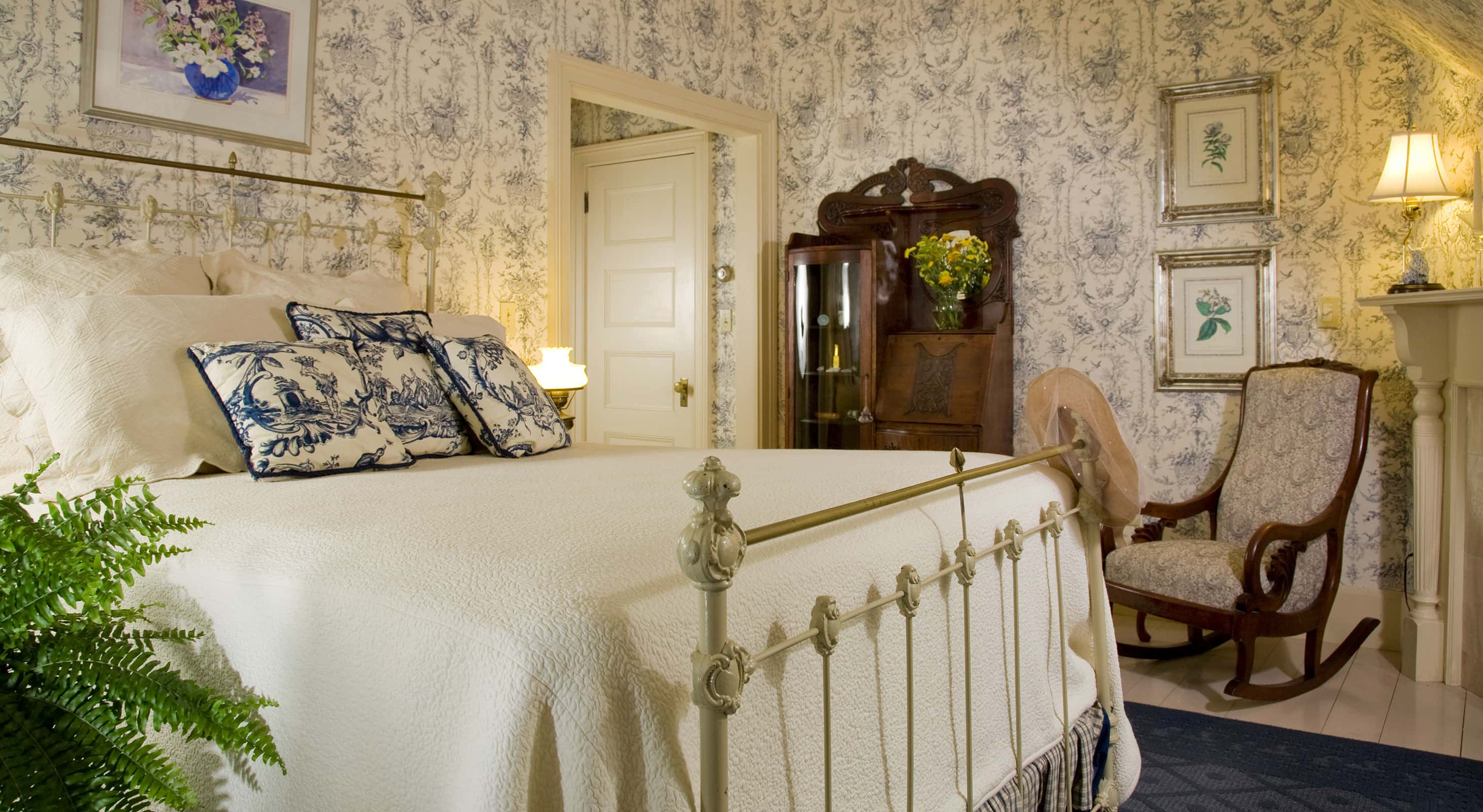 Antique-style metal bed across from ornate wooden stand in Room 7