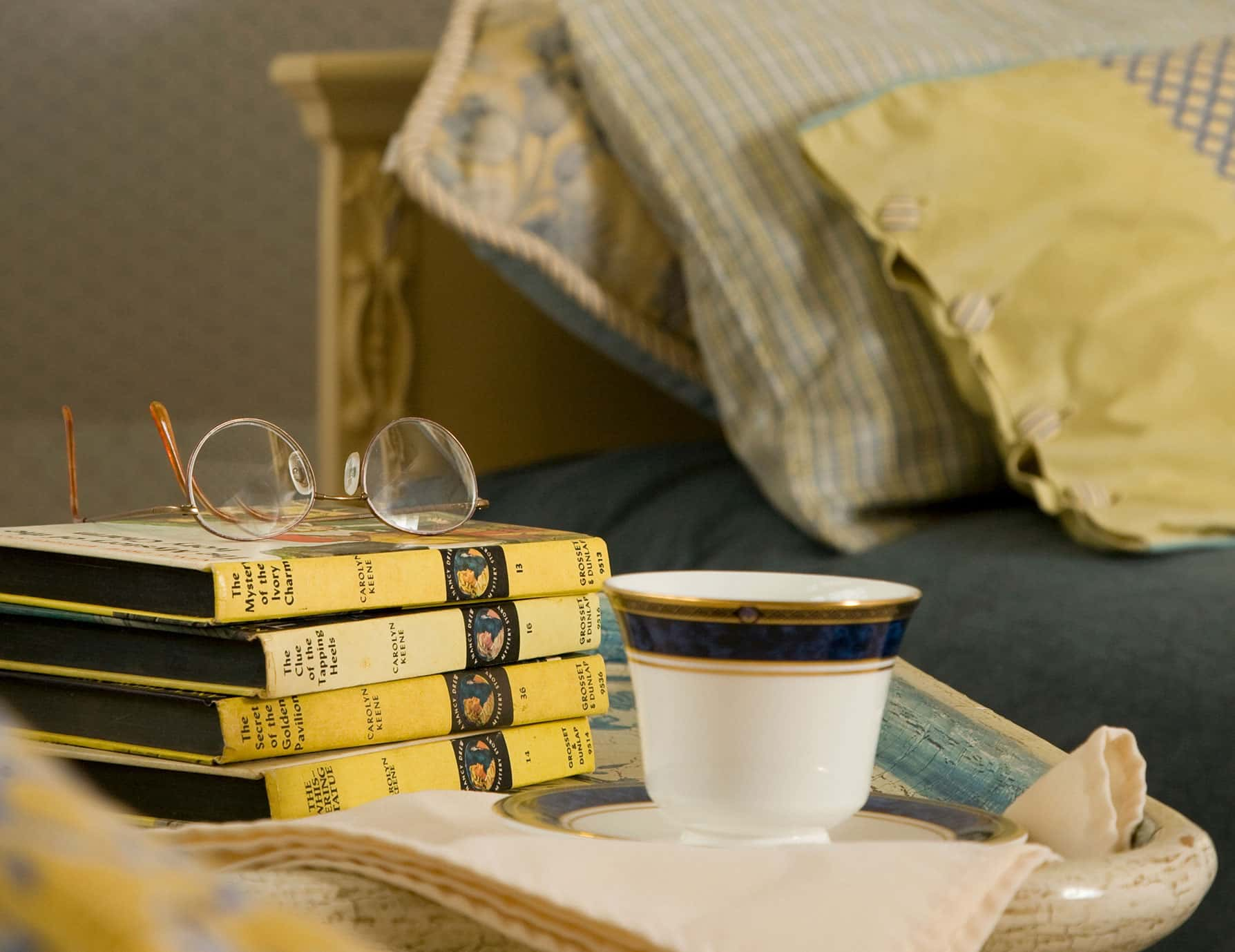 Stack of books with coffee cup on nightstand