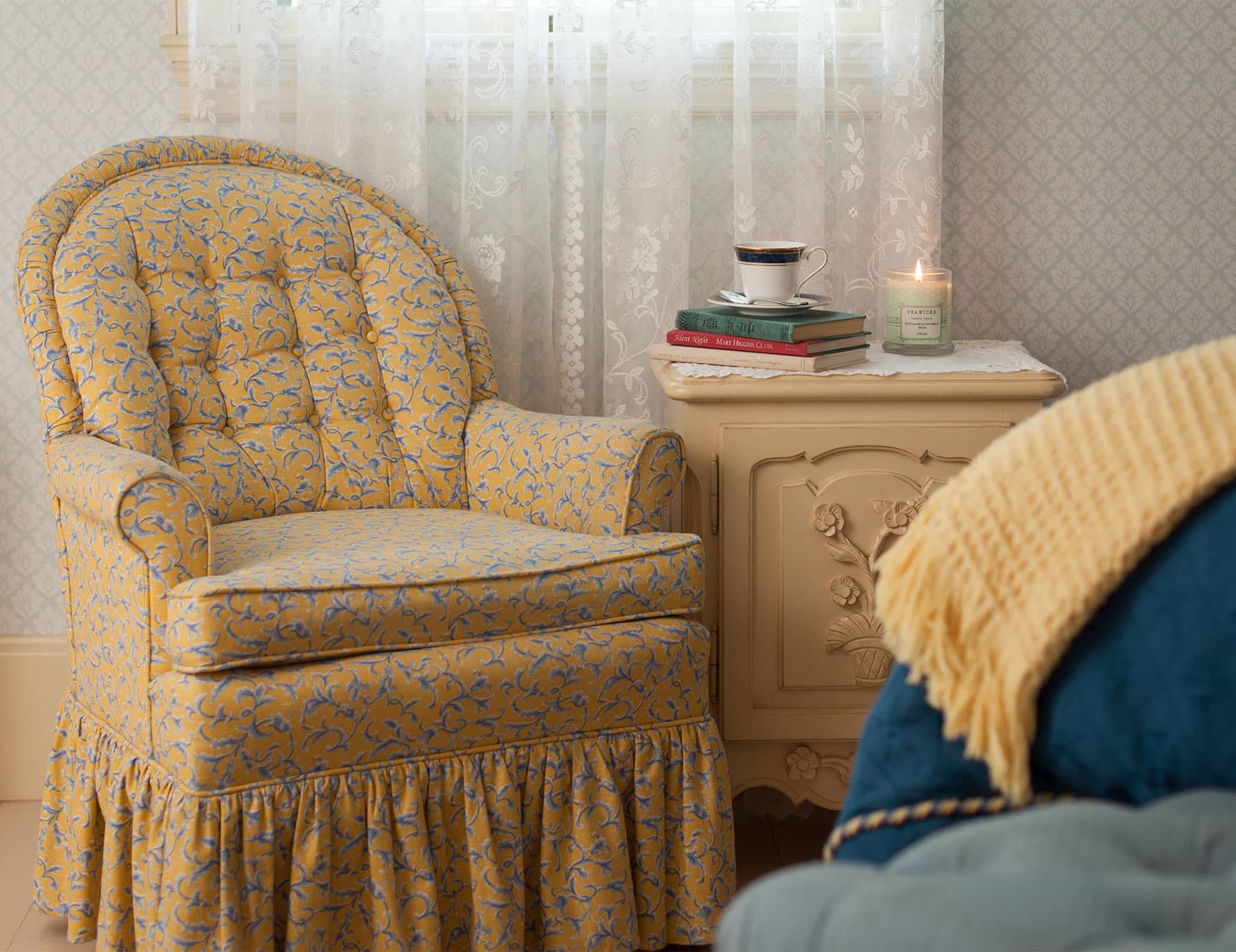 Sitting area with soft chair and stack of books on table