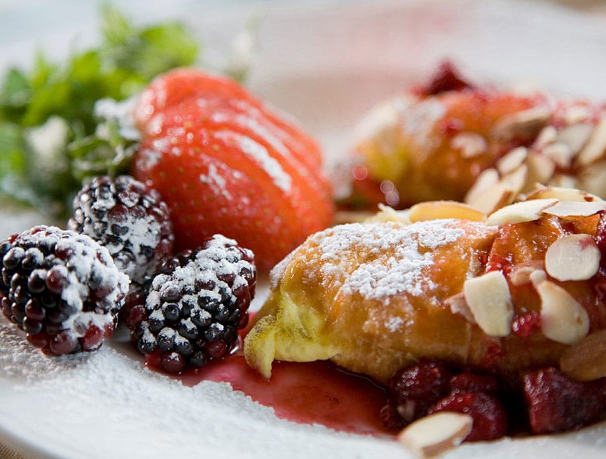 Breakfast pastry and fruit dusted in powdered sugar