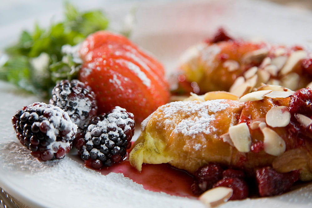 Breakfast pastry and fruit dusted in powdered sugar