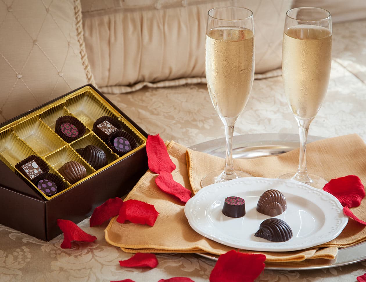 box of chocolates and 2 flutes filled with champagne