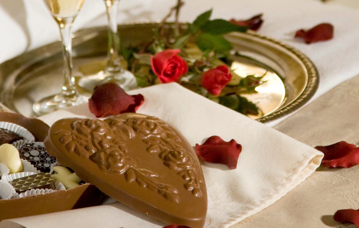 Chocolates in a heart box with rose petals