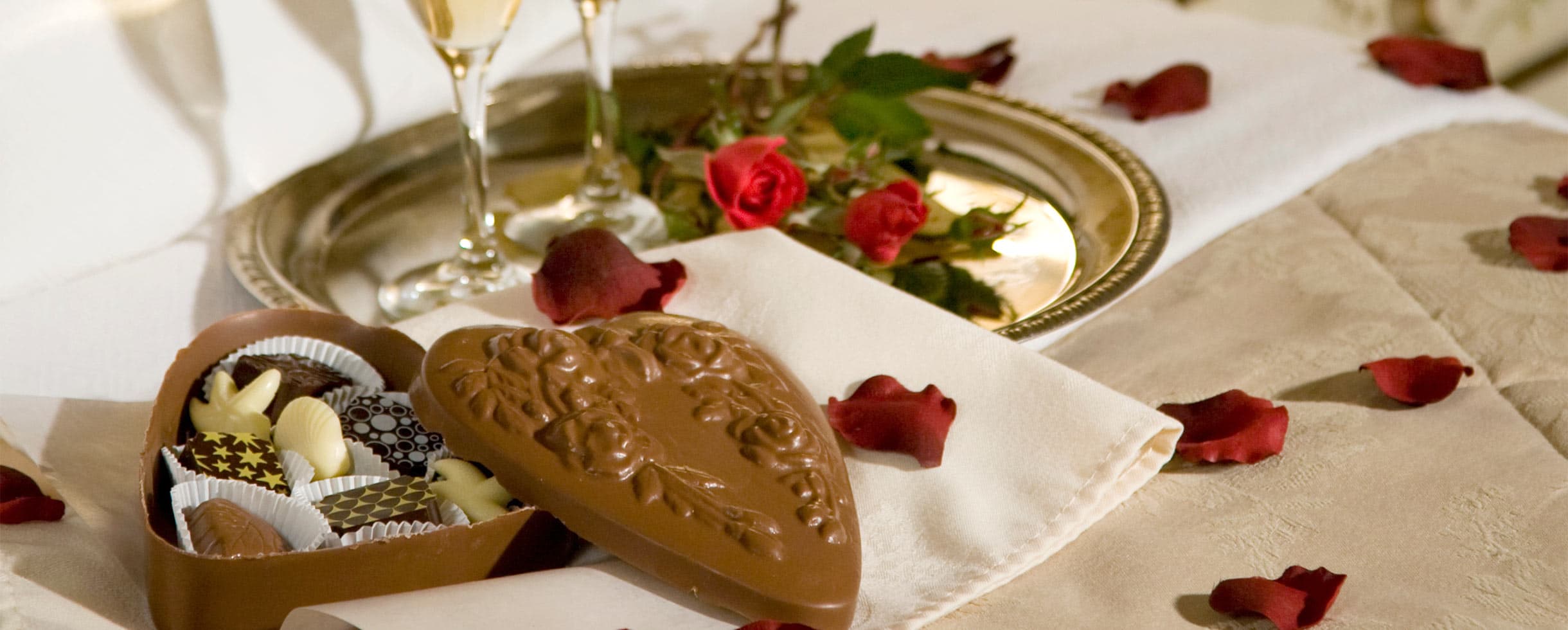 Chocolates in a heart box with rose petals