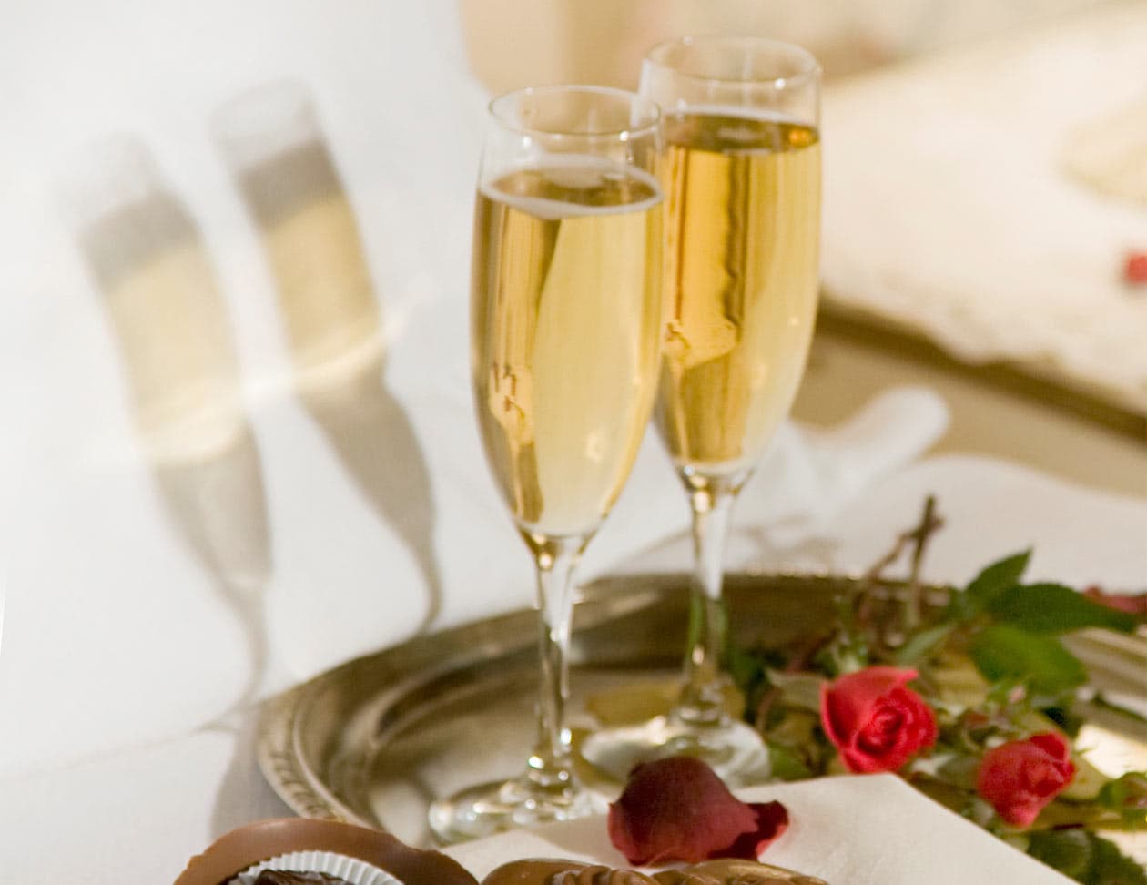 Two Wine Glasses with red rose petals