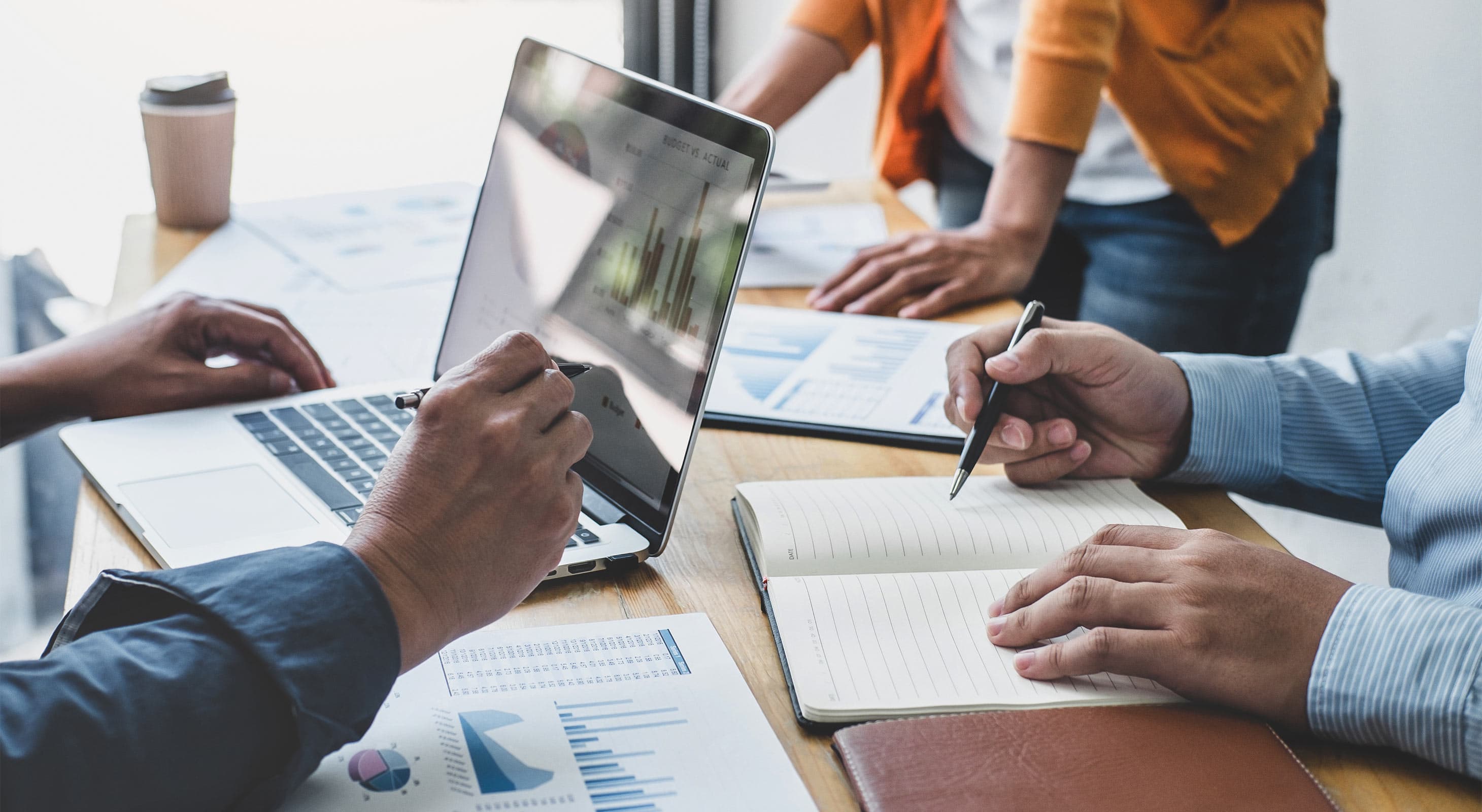 People looking at a laptop and projections during a business meeting