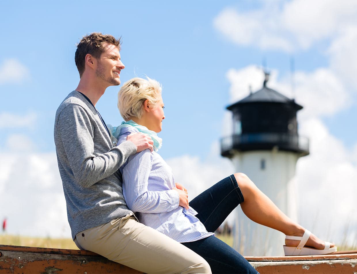 Couple with lighthouse in the distance