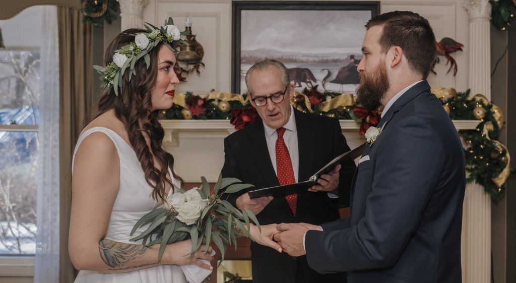 Petite wedding couple getting married in front of fireplace