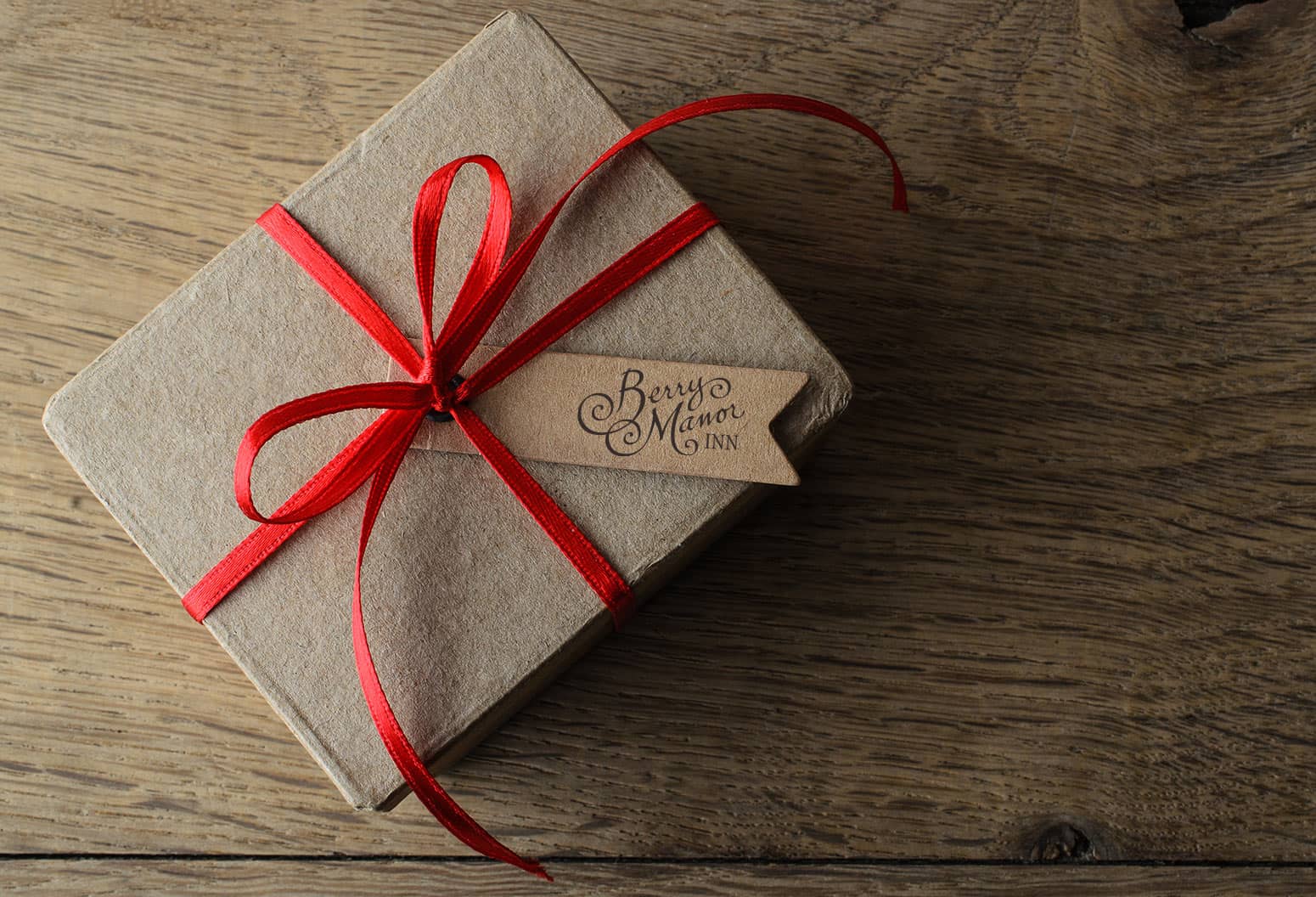 Gift Box with red bow and Berry Manor Inn logo