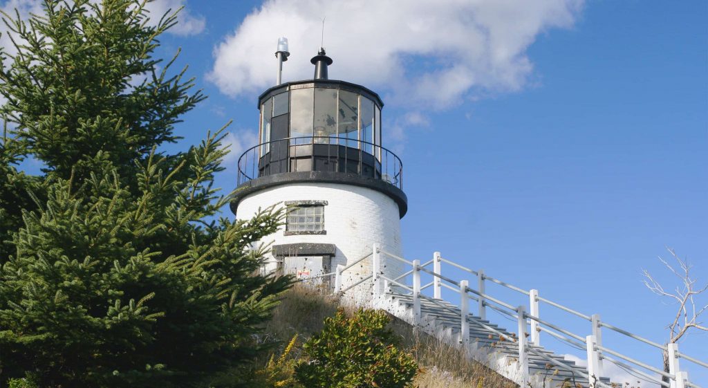 White lighthouse with black cap against a blue sky