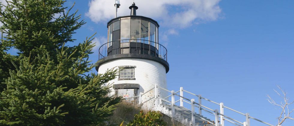 White lighthouse with black cap against a blue sky