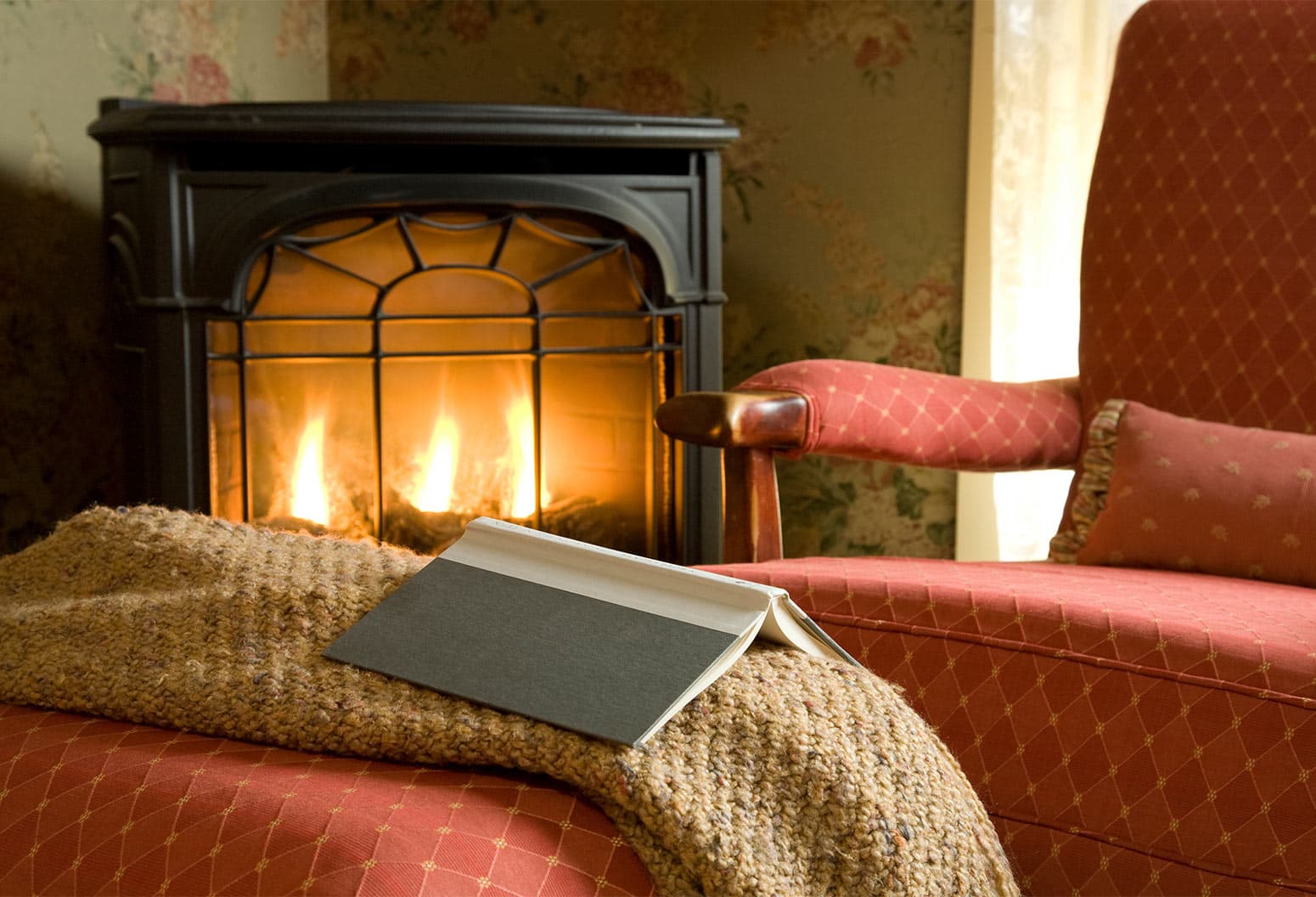 Reaching Chair next to the Fireplace with blanket and book