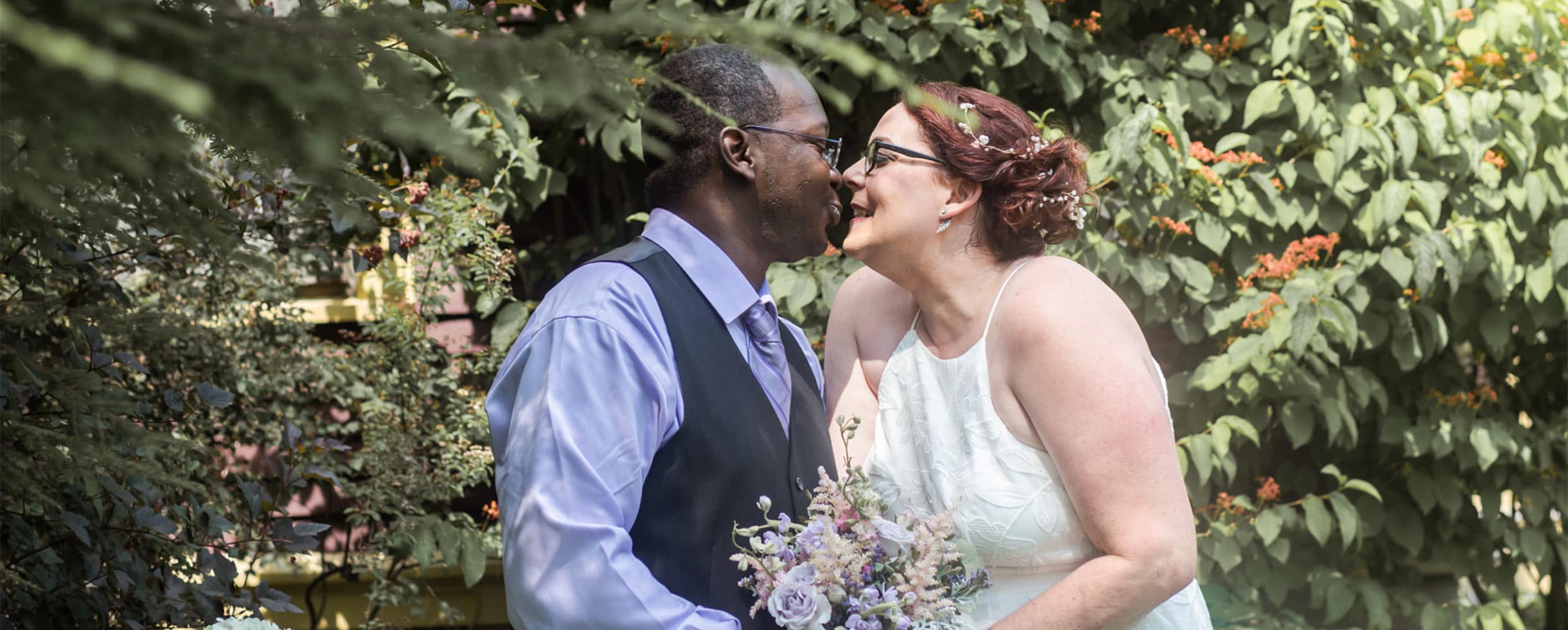 Bride and Groom about to share a kiss in the garden