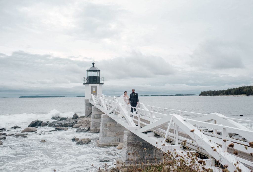 Elopement couple on the pier by a lighthouse