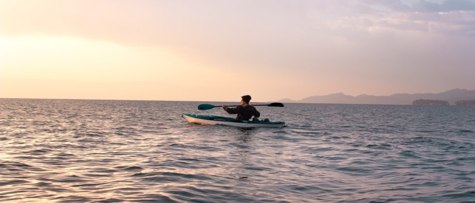 Kayaking at dusk with a pink and yellow tinged sky