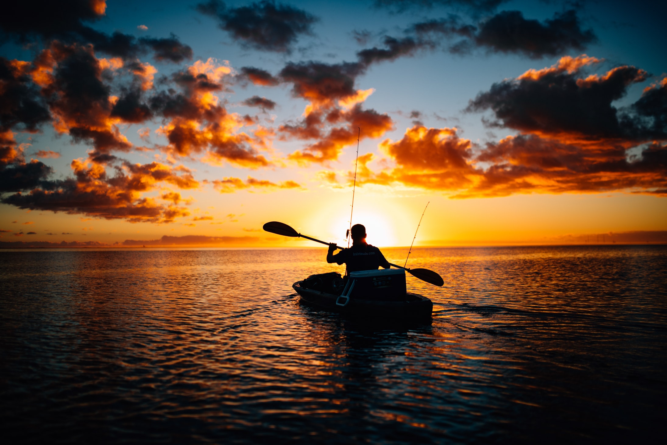 sole kayaker on ocean at sunset