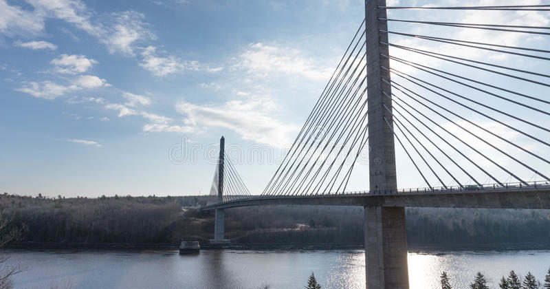 Two granite towers with cable stay suspension cables across the Penobscot river with blue sky in background