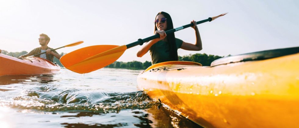 A couple is kayaking in yellow kayaks