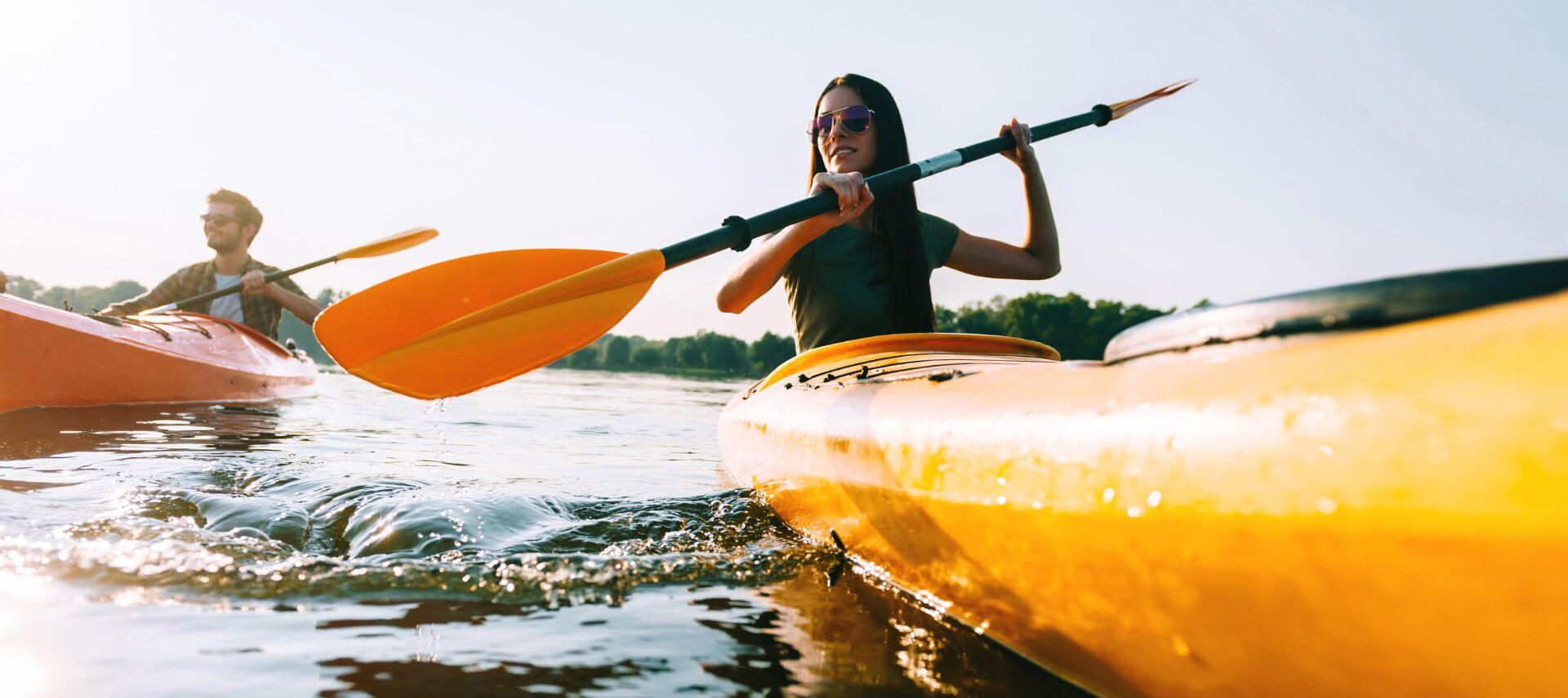 A couple is kayaking in yellow kayaks