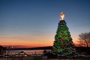 lighted Christmas tree at sunset over the ocean