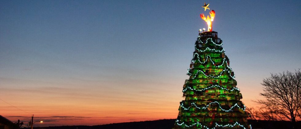 lighted Christmas tree at sunset over the ocean