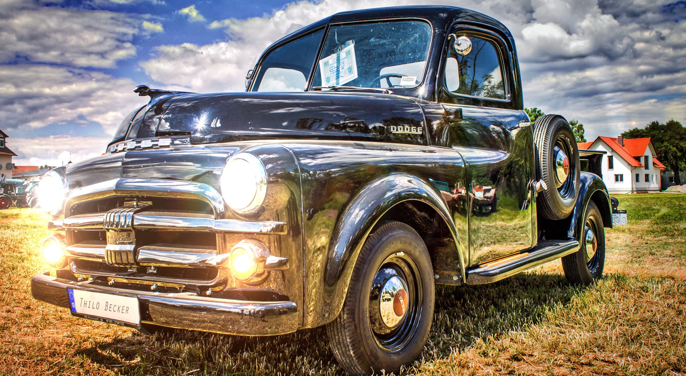 vintage silver truck with headlilghts on on green grass