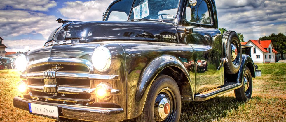 vintage truck parked outside amidst blue skies with white clouds