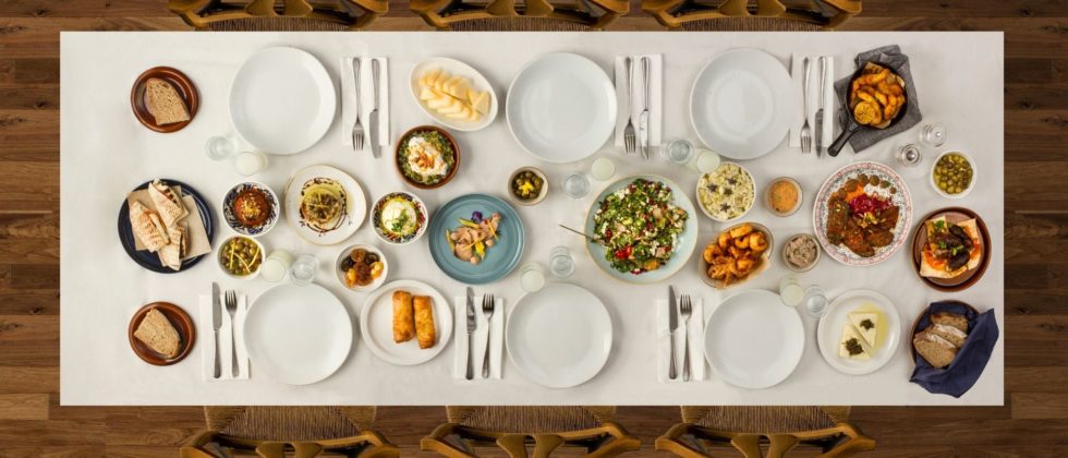 Wood table topped with plates of farm to table food