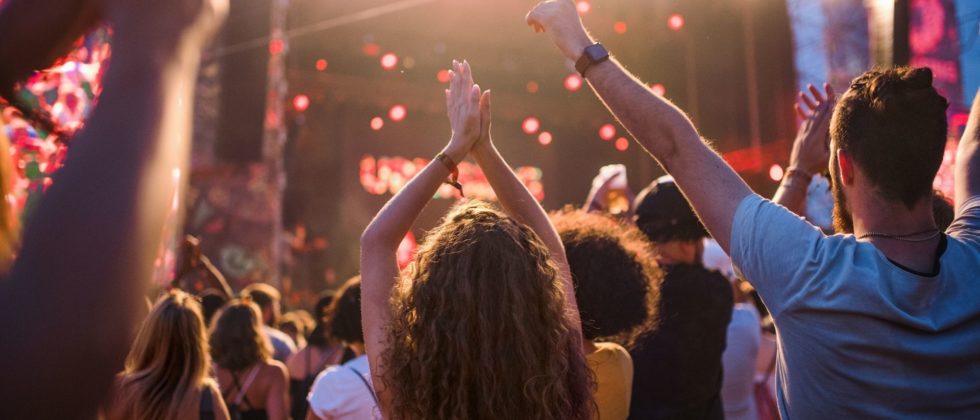 Outdoor concert with people raising their arms to the music