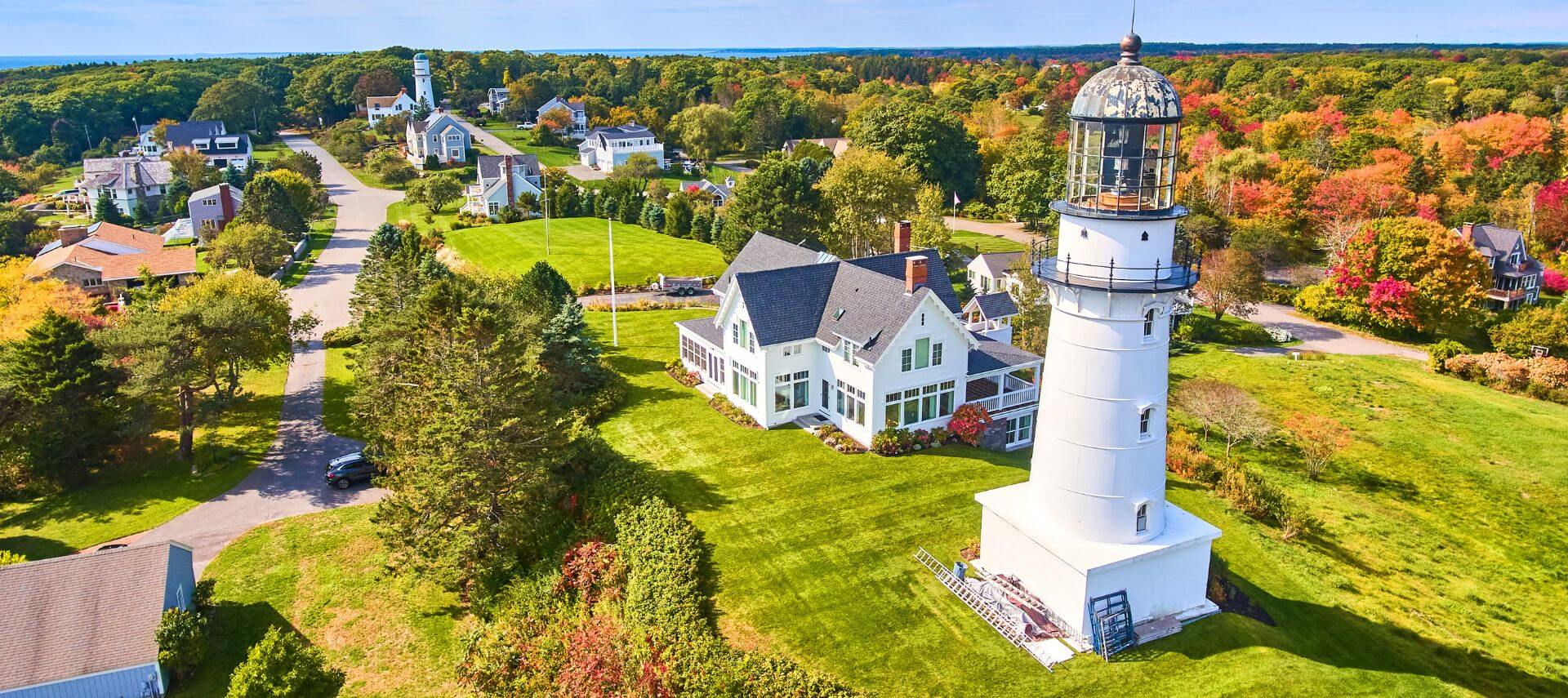 Cape Elizabeth Lighthouse with a view of the turning foliage in the background