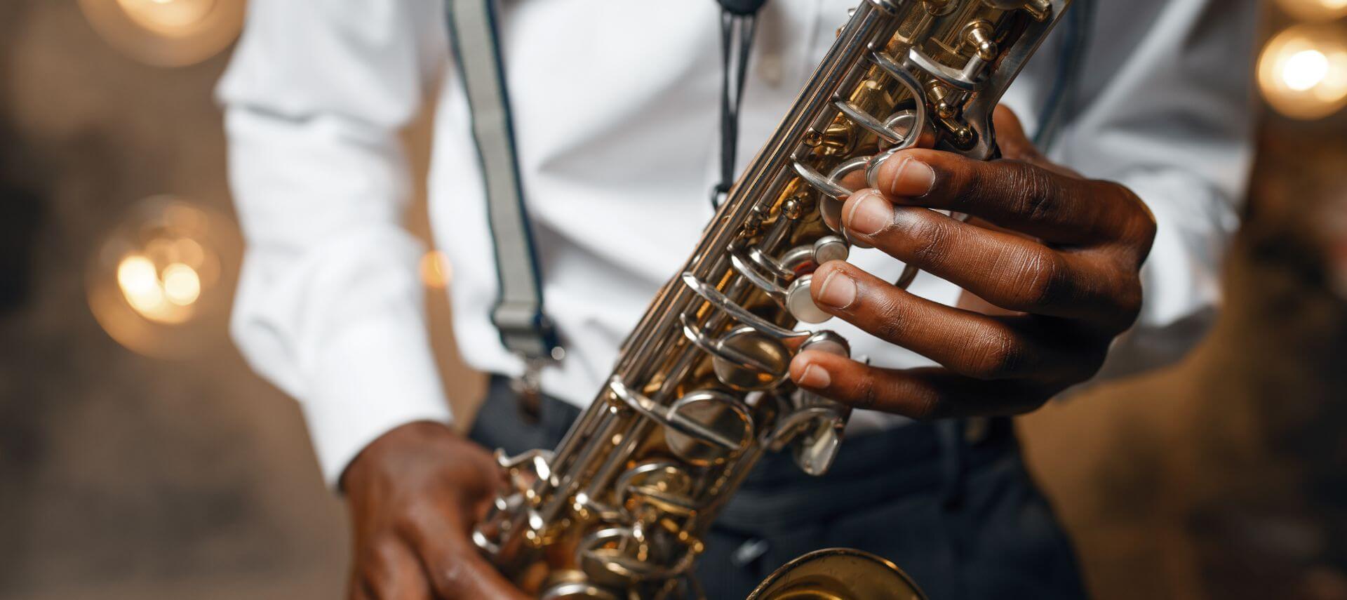 A saxophone player has fingers poised on the keys