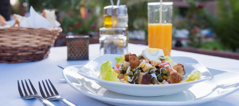 A plate of salad on a table at an outdoor dining restaurant