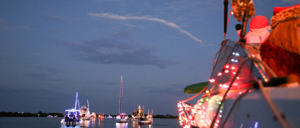 Boats in the harbor lit up during the Rockland Festival of Lights - one of the best things to do in Rockland, Maine during the holidays on MidCoast Maine